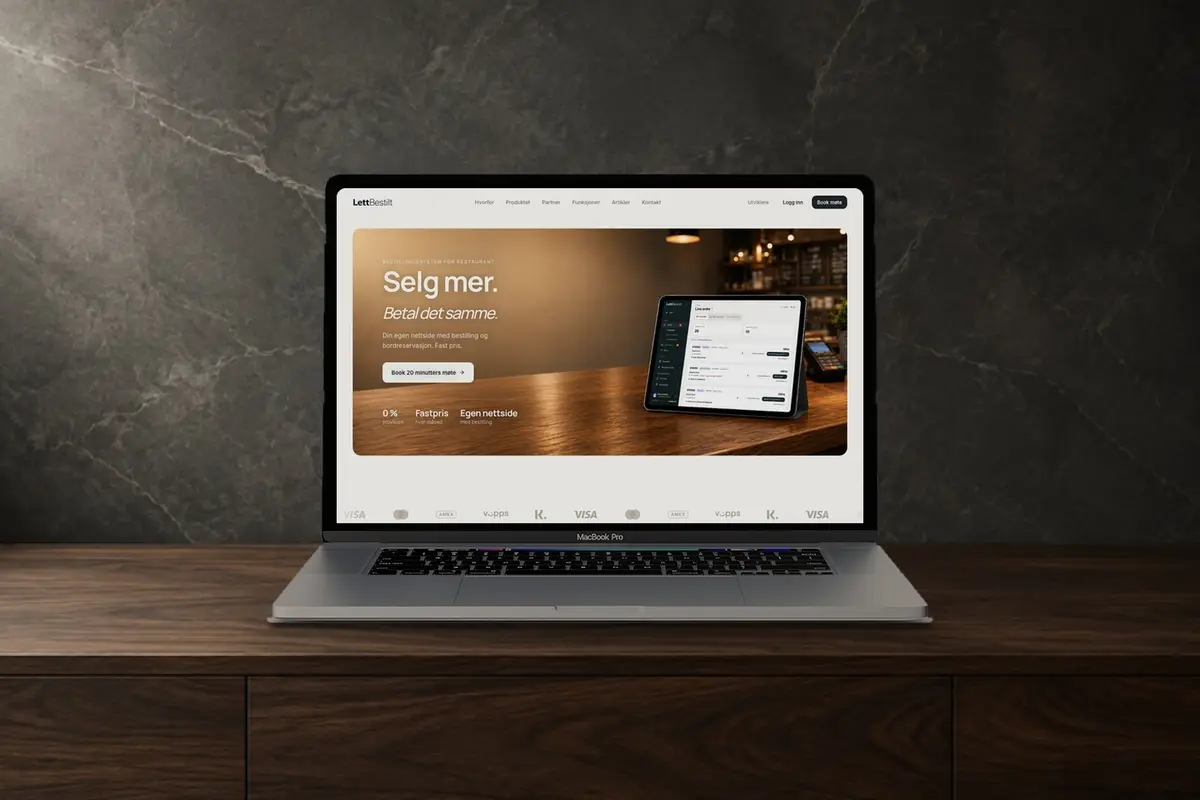 En laptop på en mørk trebenk som viser forsiden til LettBestilt