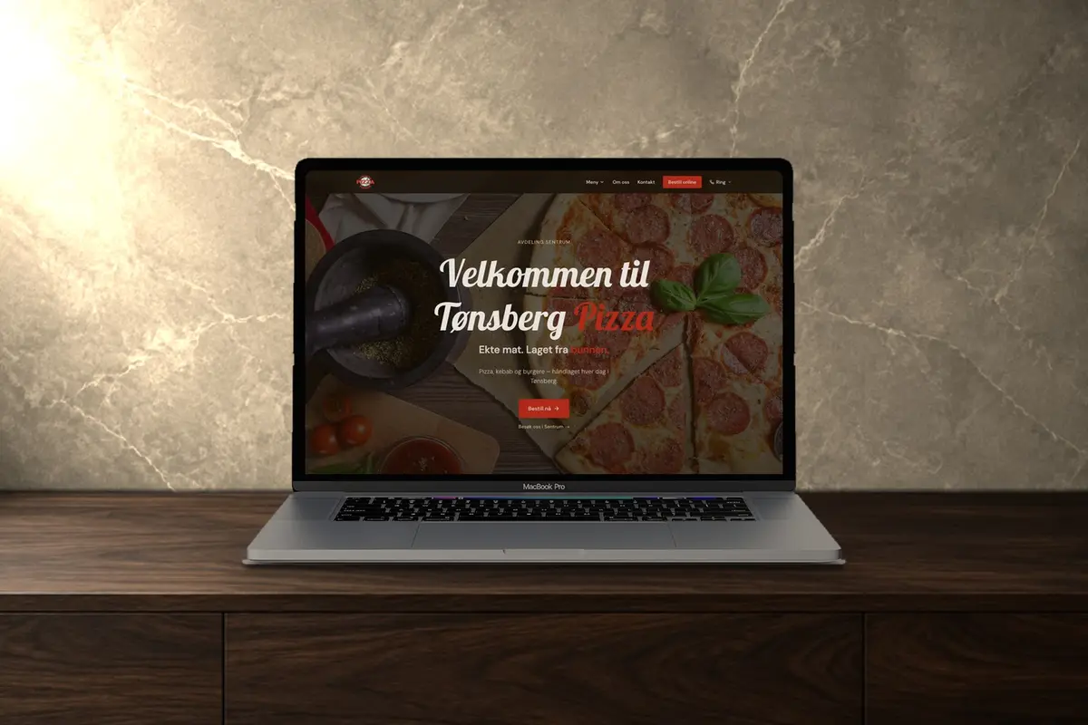 En laptop på en mørk trebenk som viser nettsiden til Tønsberg Pizza